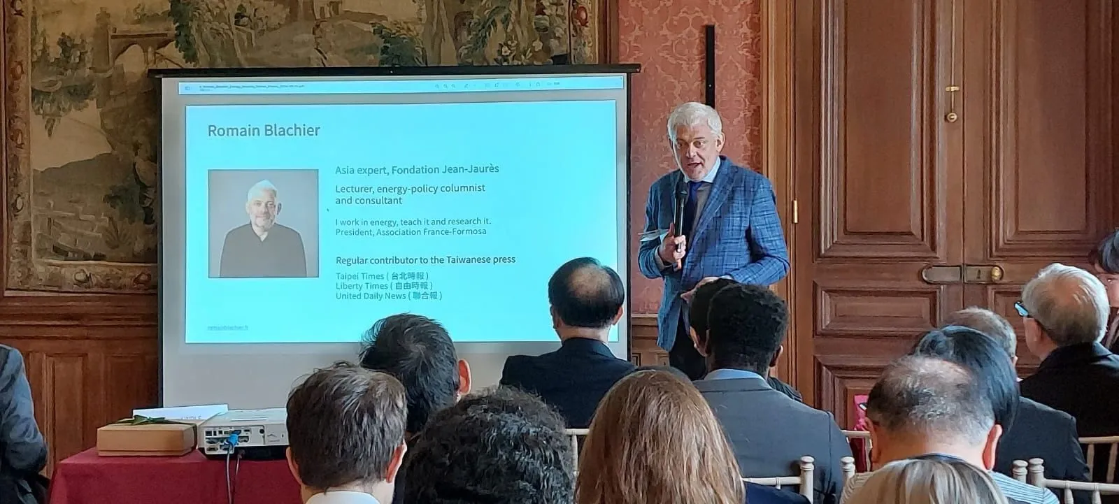 Romain Blachier, micro en main, devant l'écran de sa présentation lors de la conférence France–Taïwan à Paris.